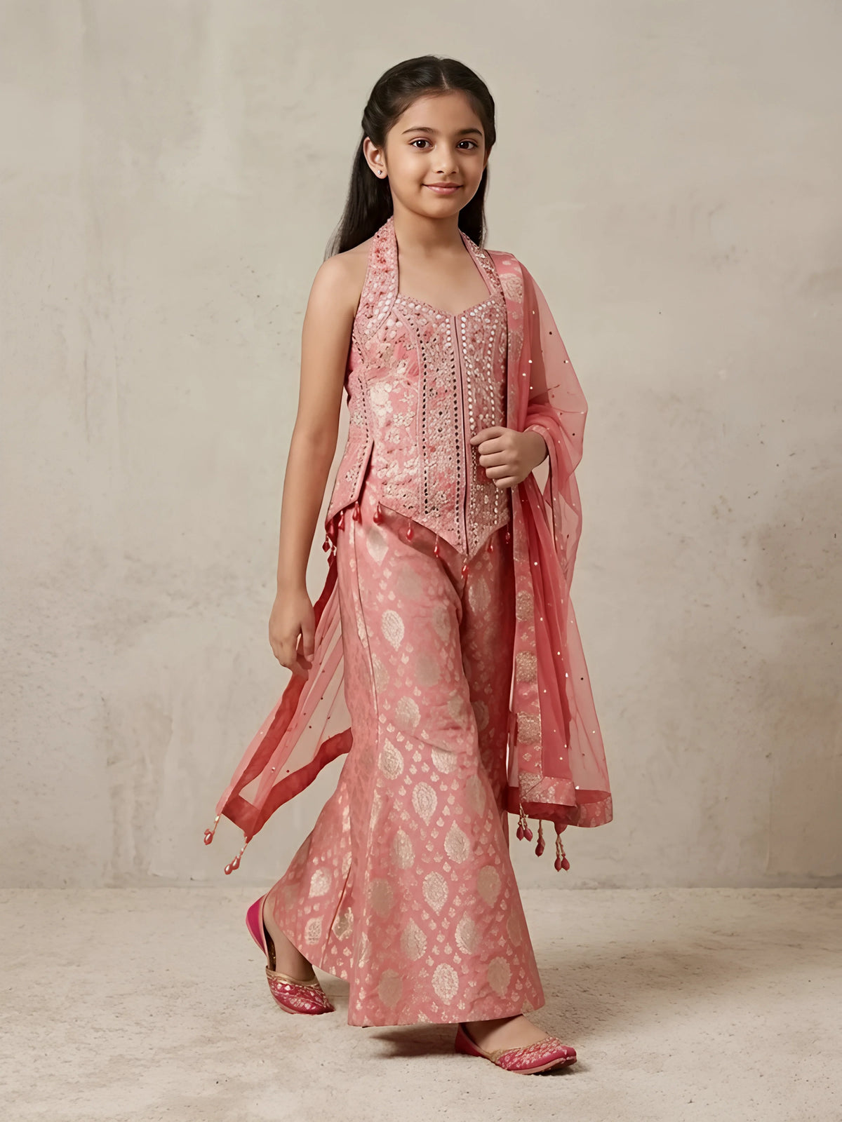 Girls pink ethnic halter-neck top with embellished mirror work and matching woven palazzo pants and net dupatta.