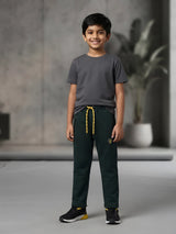 Young boy wearing dark green casual trackpants with contrast yellow drawstrings and zippered pockets