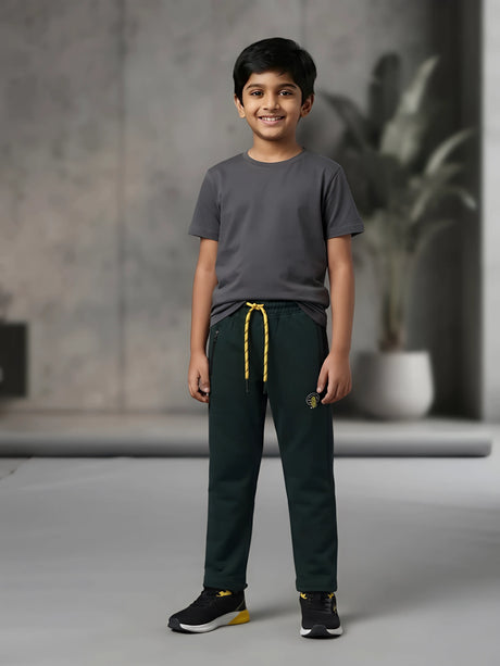 Young boy wearing dark green casual trackpants with contrast yellow drawstrings and zippered pockets