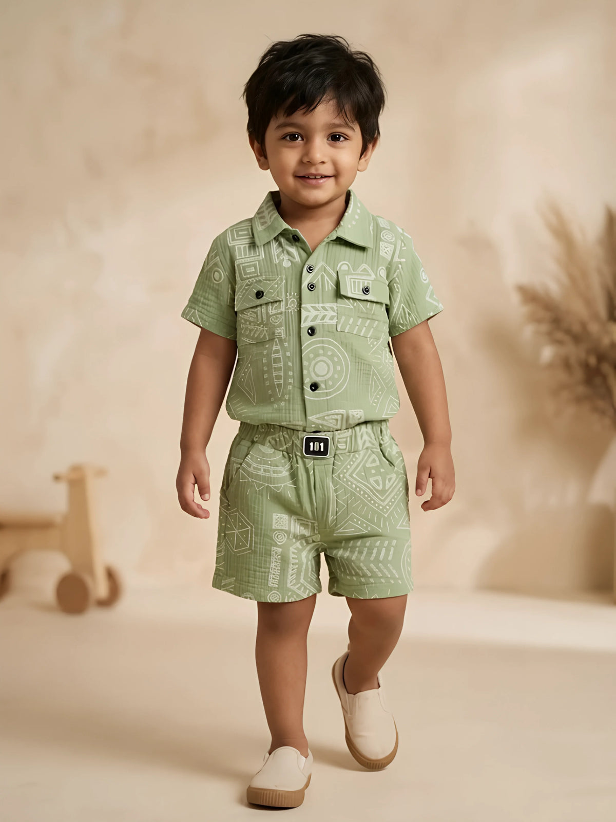 Green geometric printed shirt and shorts boys coordinate set displayed flat on a white background.