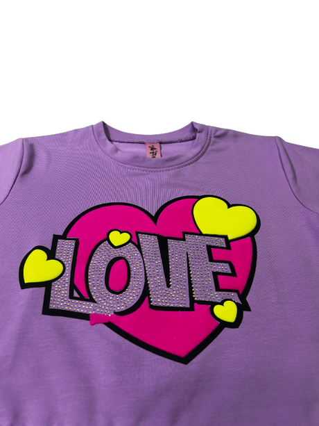 Girls' short-sleeve lavender/purple top with a large central graphic featuring a pink heart, the word 'LOVE' in white sequins, and small yellow hearts.

Export to Sheets