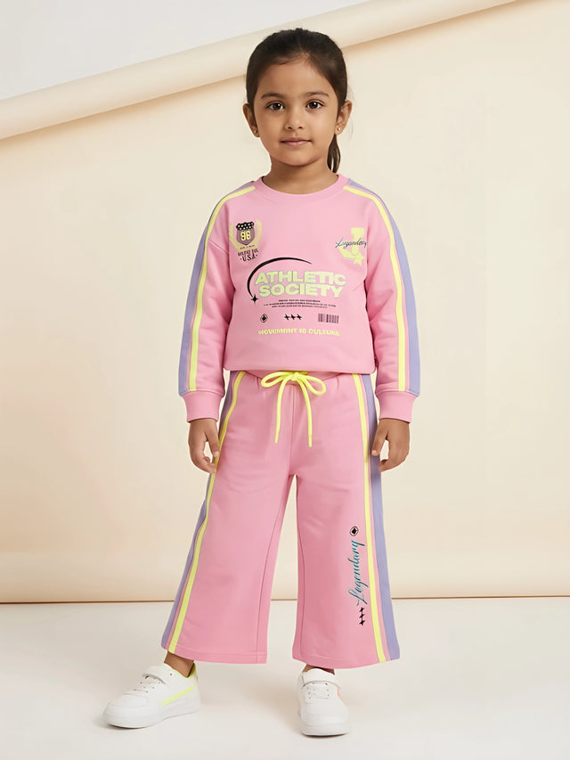 Pink graphic print girls coordinate set with sweatshirt and matching track pants with side stripes.