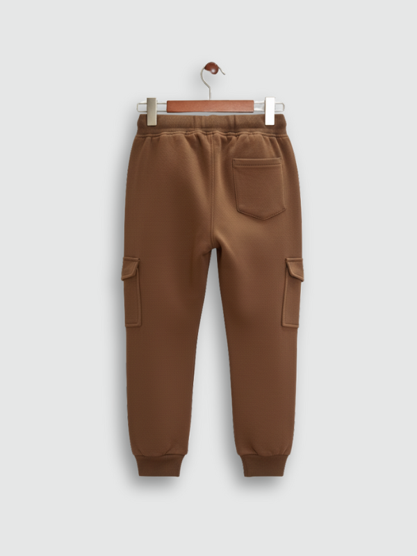 Boys' plain brown fleece cargo jogger pants with elastic drawstring waist and cuffed ankles, hanging on a wooden hanger.