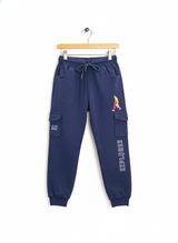 Navy blue fleece jogger pants for boys featuring cargo style pockets, a white drawstring, and the embroidered text 'EXPLORER'.