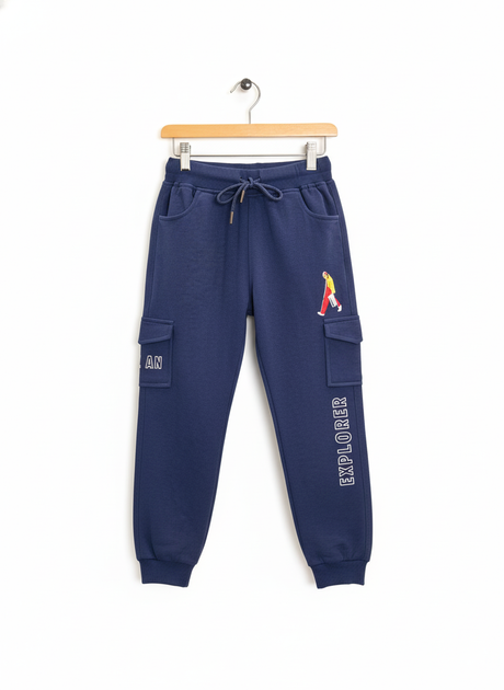 Navy blue fleece jogger pants for boys featuring cargo style pockets, a white drawstring, and the embroidered text 'EXPLORER'.