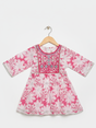 Front view of a girls' 3/4 sleeve pink and white floral-printed peplum top (kurti) with a heavily embroidered and mirror-work detailed yoke, hanging on a wooden hanger.