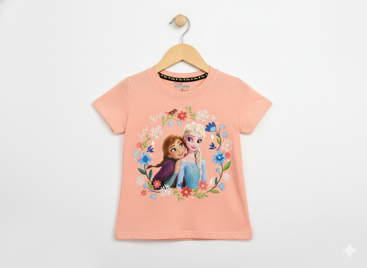 Disney Frozen Anna and Elsa hugging graphic print inside a colorful floral wreath on a peach/coral girls' short-sleeve T-shirt hanging on a wooden hanger against a white background.
