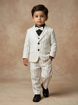 Young boy wearing a white pinstriped coat suit set with blazer, waistcoat, black shirt, and matching bow tie