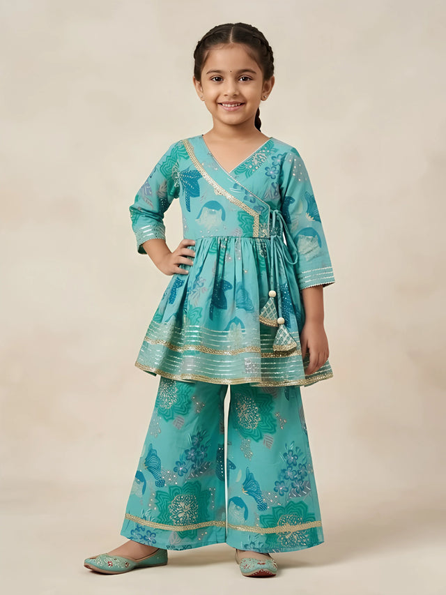 Young girl wearing a sea green floral printed Angrakha kurti with tassel side tie-ups and matching flared sharara pants.