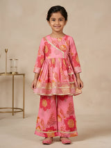 Young girl wearing a pink floral printed Angrakha style peplum kurti with flared sharara bottoms and gold lace trimming