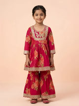 Young girl wearing a red floral printed sharara set with gold embroidery work