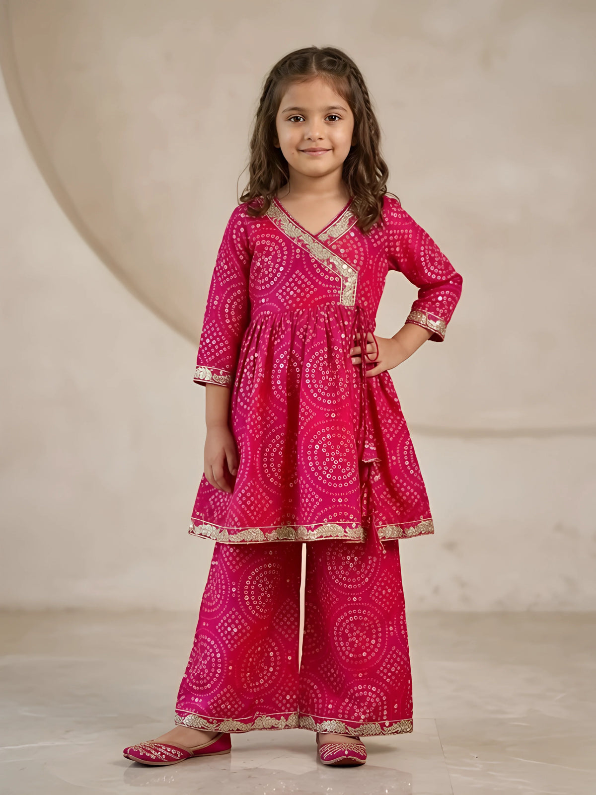 Young girl wearing a vibrant pink embroidered kurta and matching flared sharara set for festive occasions
