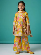 Girl wearing a green floral printed Angrakha kurti and flared sharara suit set with tassel details and matching dupatta