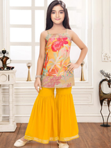 Young girl modeling a sleeveless ethnic set with a colorful floral-print top and voluminous, tiered yellow sharara pants with a metallic border.