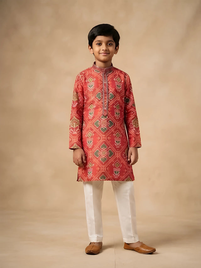 Boy wearing a red full sleeve printed kurta paired with white pyjamas