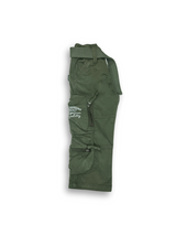 Boys' dark olive green cargo pants with many zippered side pockets, a matching web belt, and cuffed or slightly cropped leg openings.

Export to Sheets