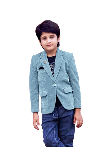 Young boy wearing a light blue corduroy blazer with a lapel pin, styled over a black t-shirt and dark blue denim jeans.