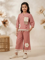 Girls peach two-piece set featuring a buttoned tunic top with fringe patch pocket and matching lace-trimmed trousers.