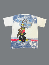 White boys' short-sleeve T-shirt with a blue "MOSCHINO" designer-inspired logo and a cartoon rabbit character graphic, against a neutral background.