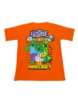 Vibrant Orange boys' short-sleeve T-shirt with the white Minecraft logo and a scattered pattern of green and yellow pixelated blocks graphic printed centrally.