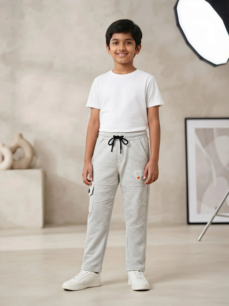 Young boy wearing light grey casual cargo trackpants with black drawstring and white t-shirt