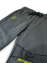 Boys' dark charcoal grey knit or fleece track pants with an elastic waist, pockets, and neon yellow "TENNIS" and tennis ball graphics on the legs.

Export to Sheets