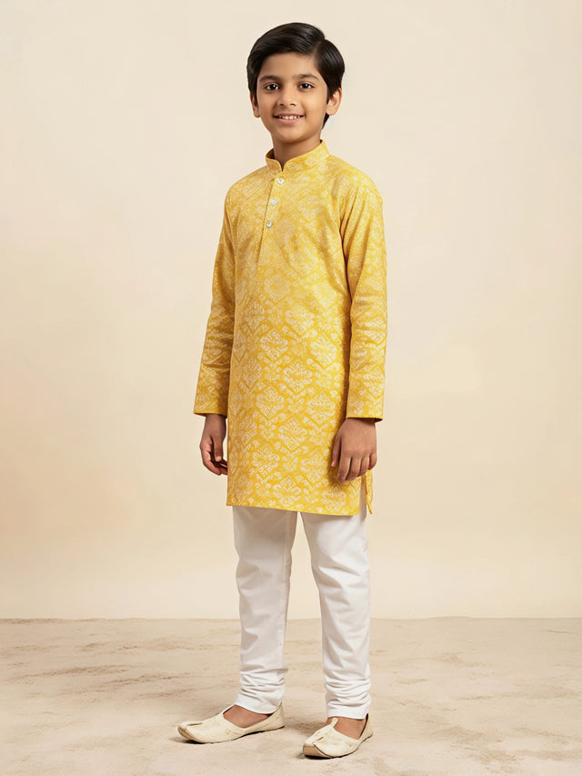 Yellow floral print kurta pajama set for boys with white pants.