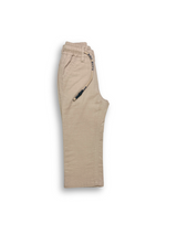 Boys' cream or pale khaki casual trousers with a comfortable elastic waistband, straight leg, and a thick, multicolored contrast rope drawstring.