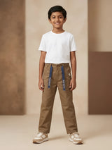 Young boy wearing brown casual trousers with navy blue printed tape detail and a white t-shirt.