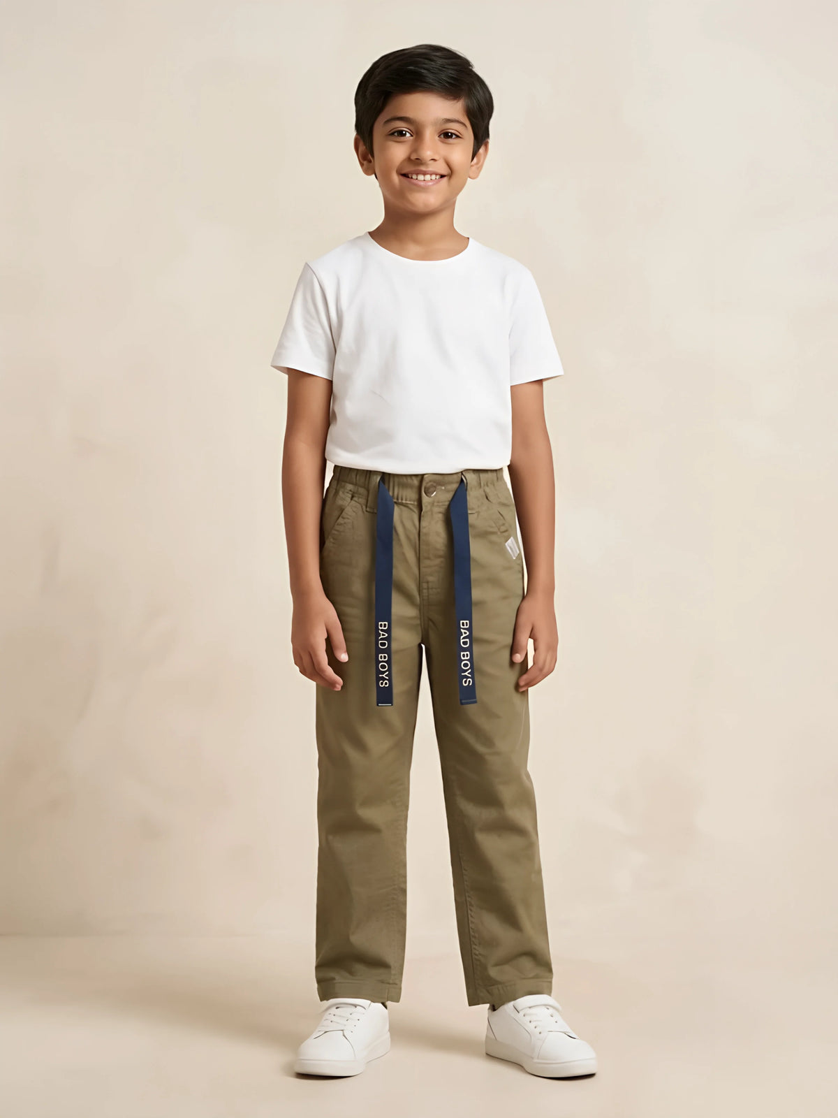 Young boy wearing olive green casual trousers with blue decorative drawstrings and a plain white t-shirt