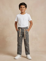 Young boy wearing stylish grey casual trousers with drawstring details and white t-shirt