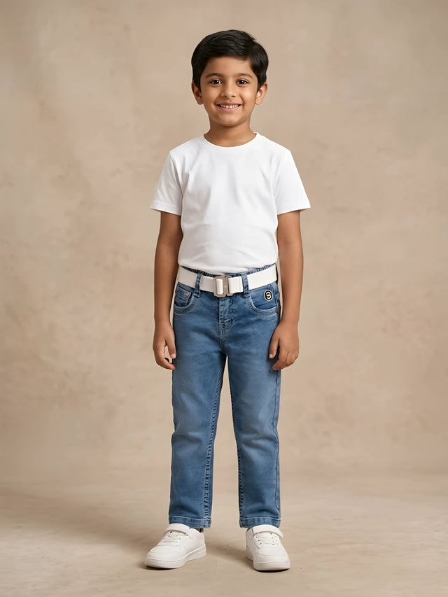 Young boy wearing stylish blue medium wash jeans with a white t-shirt and belt