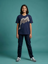 Girl wearing a navy blue round neck short sleeve t-shirt with a grey abstract graphic print