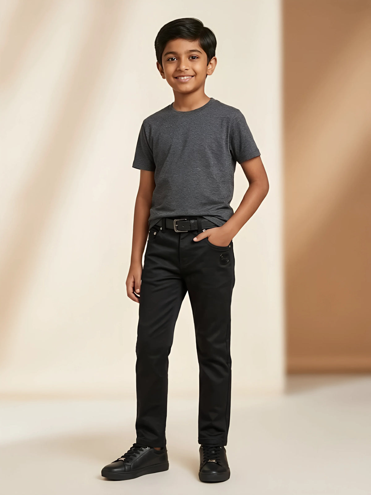 Young boy wearing black slim fit casual pants with dark grey t-shirt and black sneakers