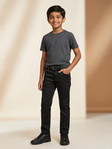 Young boy wearing black slim fit casual pants with dark grey t-shirt and black sneakers