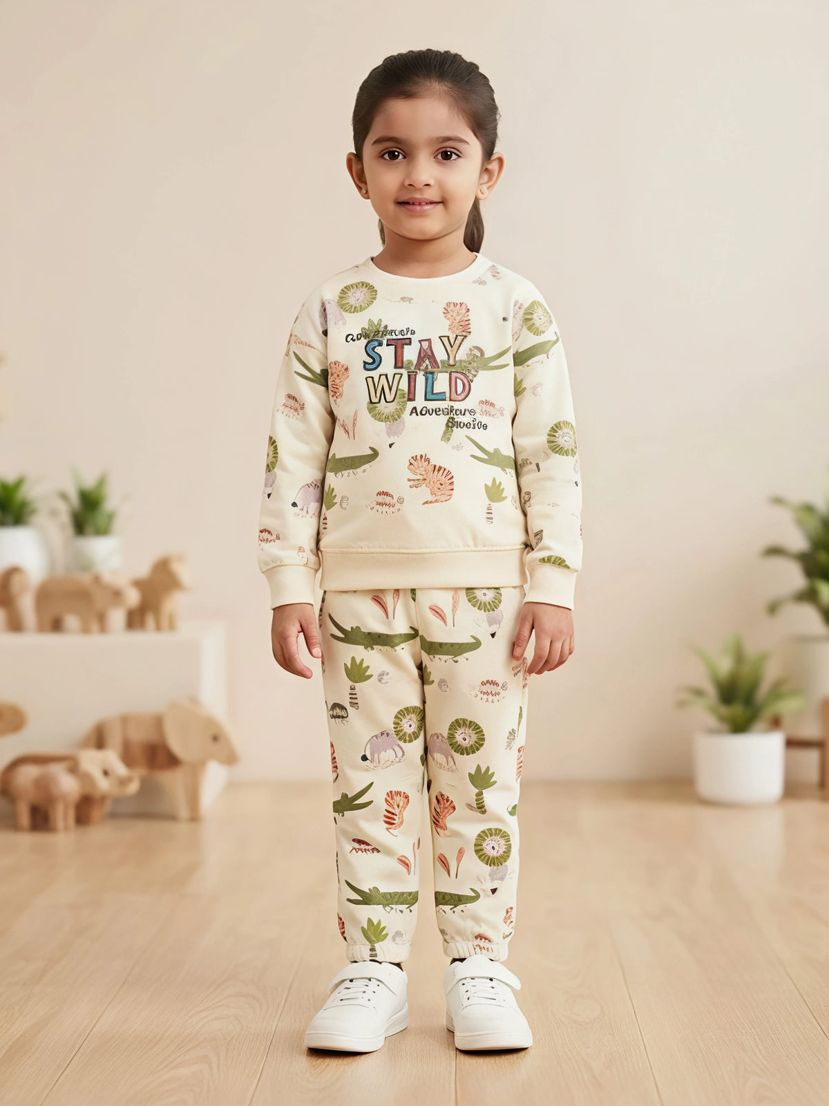 Girls cream two-piece set featuring a long sleeve Stay Wild graphic sweatshirt and matching all-over printed joggers.