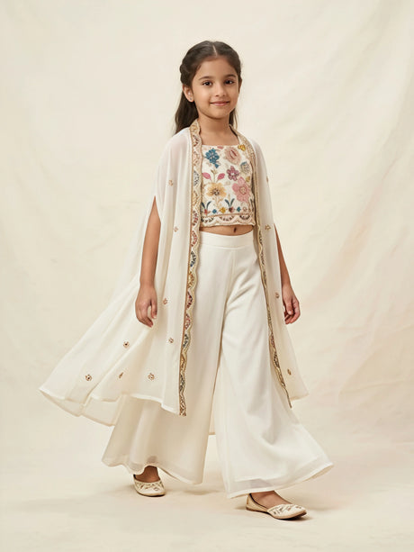 Girls cream ethnic set featuring floral embroidered crop top, wide-leg palazzo pants, and long cape shrug