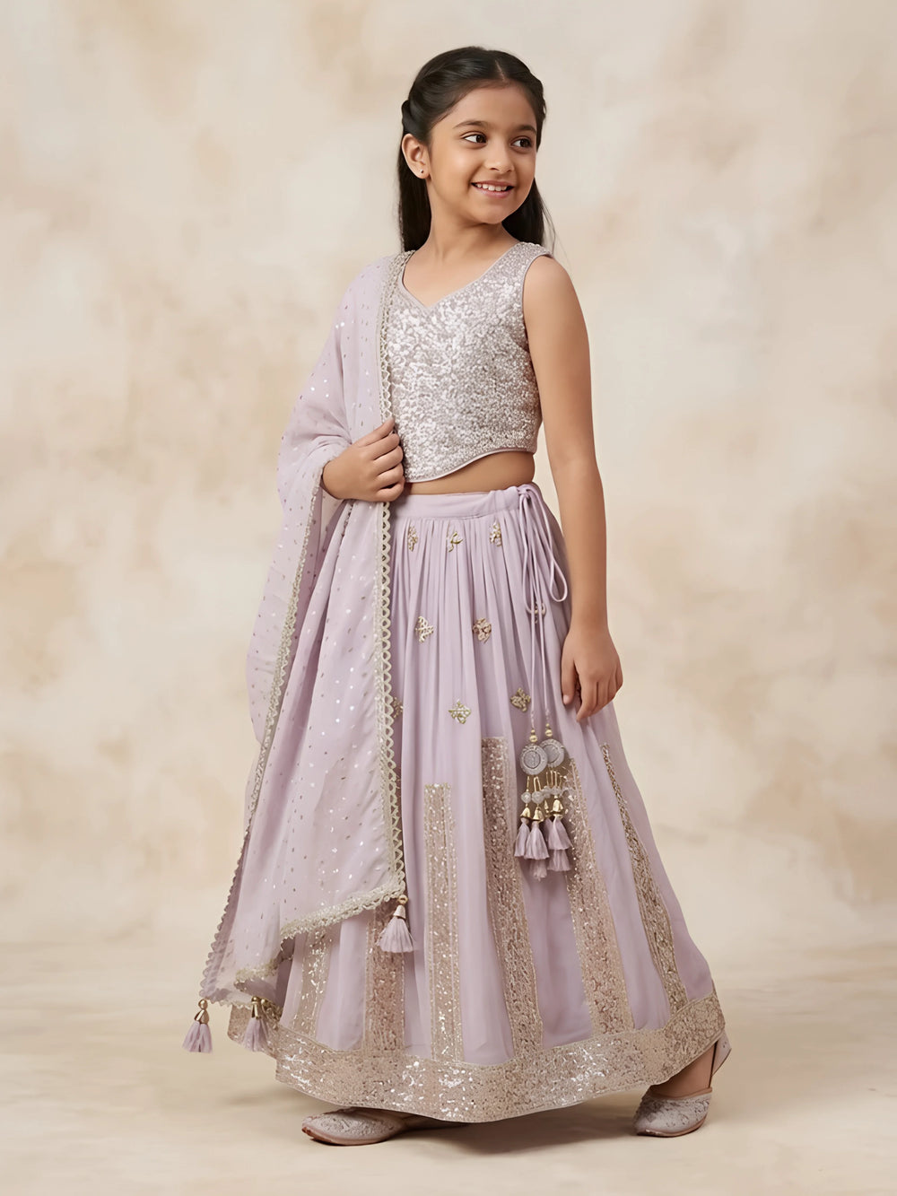 Young girl wearing a sleeveless purple sequined choli set with a flared lehenga skirt and matching dupatta