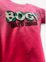 Vibrant fuchsia pink boys' short-sleeve T-shirt with a central "BOGY" graphic with teal and white pattern and scattered blue paint splatters