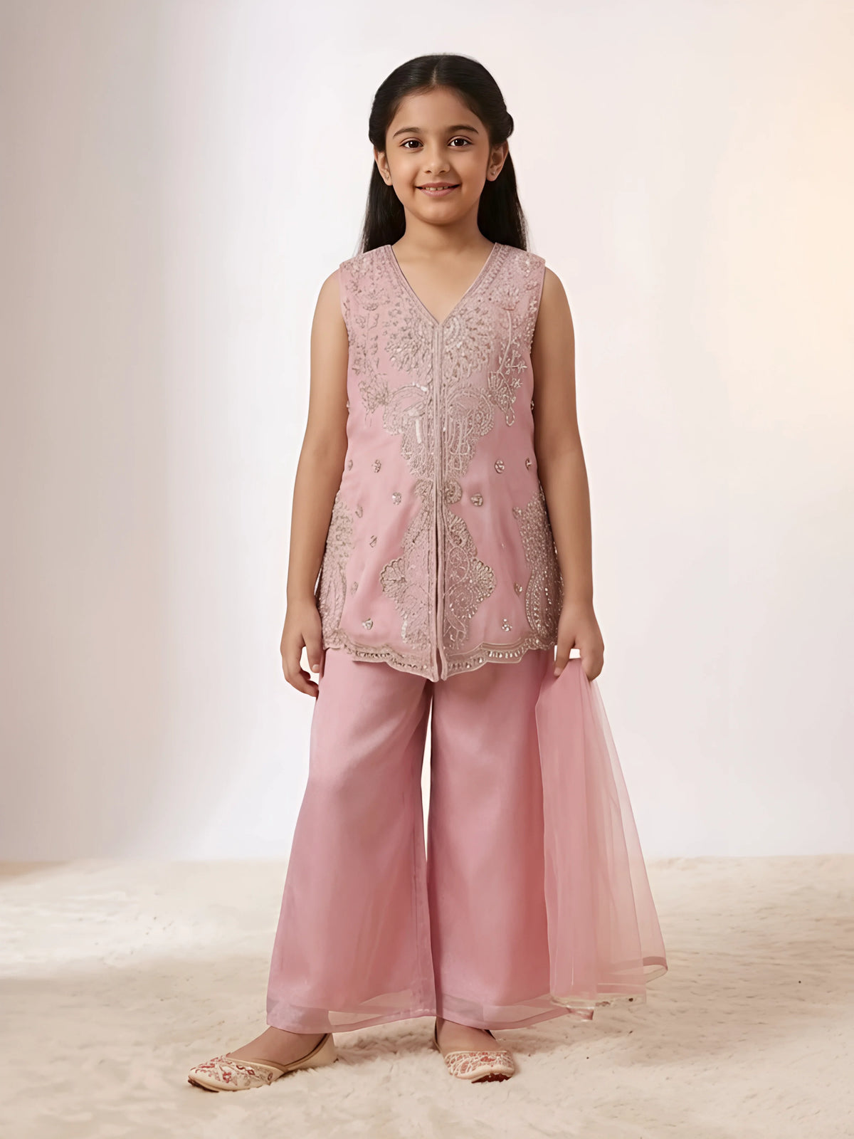 Young girl wearing a pink embroidered sleeveless kurti with matching wide-leg palazzo trousers and net dupatta