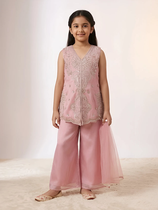 Young girl wearing a pink embroidered sleeveless kurti with matching wide-leg palazzo trousers and net dupatta