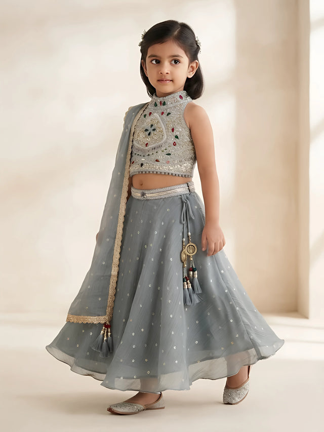 Green embellished halter neck choli set featuring intricate stonework and a flared skirt.