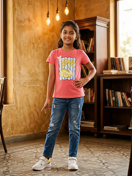Young girl wearing a peach t-shirt with a lemon graphic print and blue distressed jeans