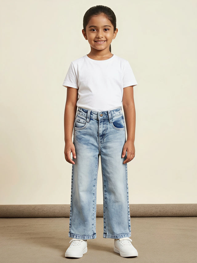 Young girl wearing light blue straight-fit casual denim pants with a white t-shirt and white sneakers