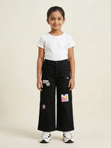 Young girl wearing black wide leg casual pants with graphic patches and front pockets