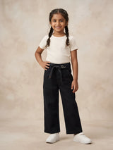 Young girl wearing black high-waisted wide-leg casual pants with a fabric tie-belt and side pockets paired with a white t-shirt and sneakers