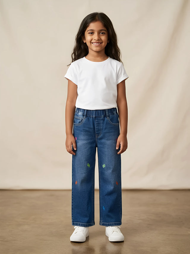 Young girl wearing blue embroidered wide-leg casual pants paired with a white t-shirt and white sneakers
