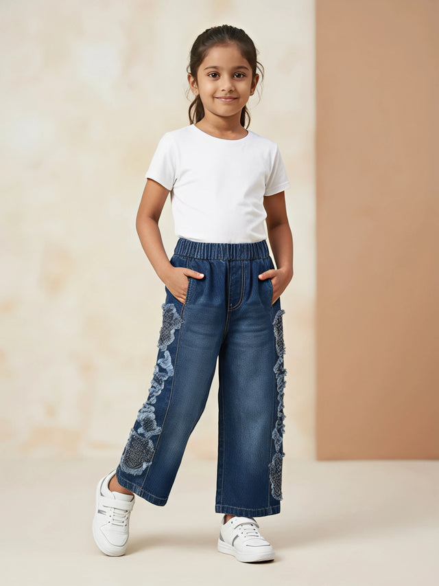 Young girl wearing Navy Blue Casual Pants with side lace detailing, elastic waistband, and side pockets paired with a white t-shirt and white sneakers.