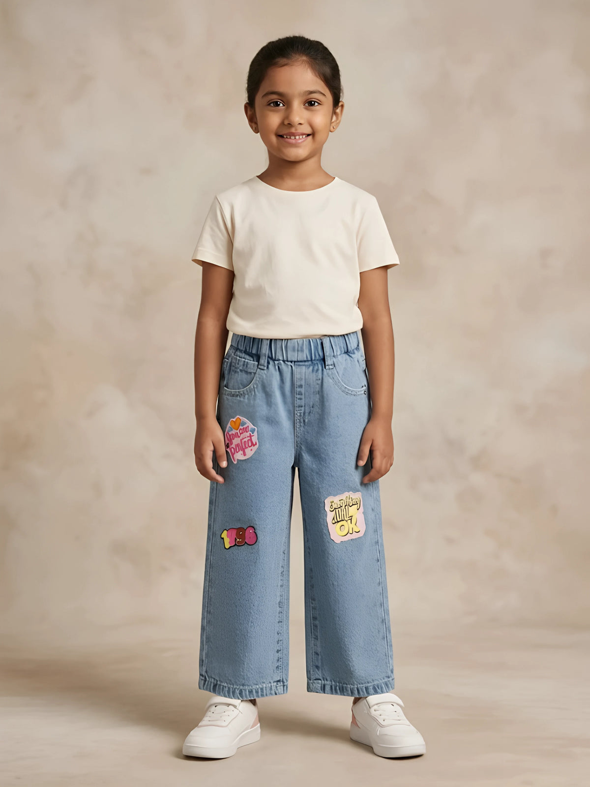 Young girl wearing light blue wide-leg casual pants with graphic patches and elastic waistband