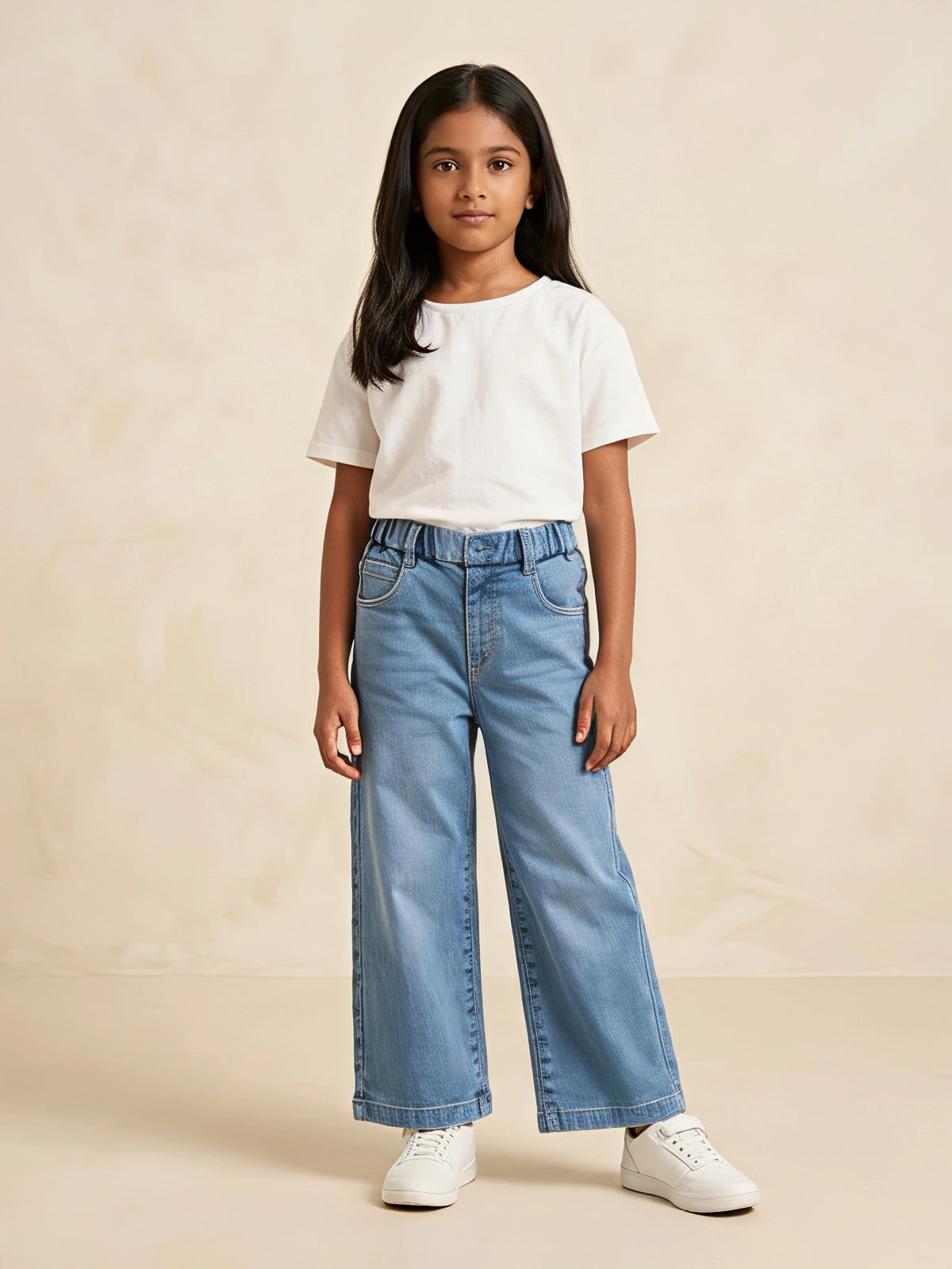 Young girl wearing light blue wide-leg casual pants paired with a white t-shirt and white sneakers